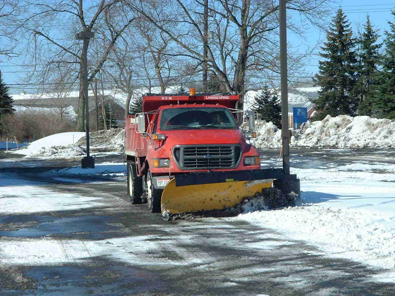 Large Dump Truck with Snowplow Plowing Snow in Cleveland Area Parking Lot