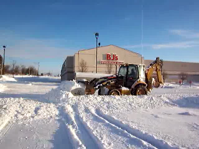 Backhoe Snow Plowing Cleveland Parking Lot