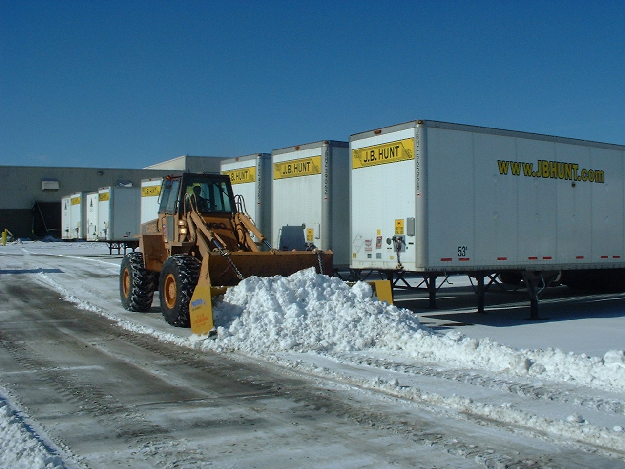 Wheeled, Front-end Loader with Snow Pusher Box Plowing Snow at a Commercial Property in Cleveland